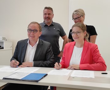 Landrat Markus Bauer und Julia Stöcker, dahinter Michael Stöhr, Verbandsgemeindebürgermeister Egelner Mulde, und Prokuristin Peggy Neum, MVZ Bodeaue, bei der Unterzeichnung der Vereinbarung in Egeln.